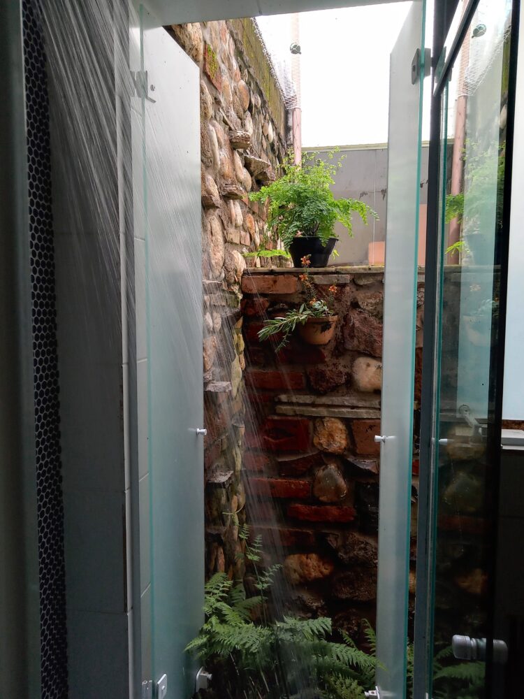 Banheiro compacto com integração ao jardim e soluções de baixo custo